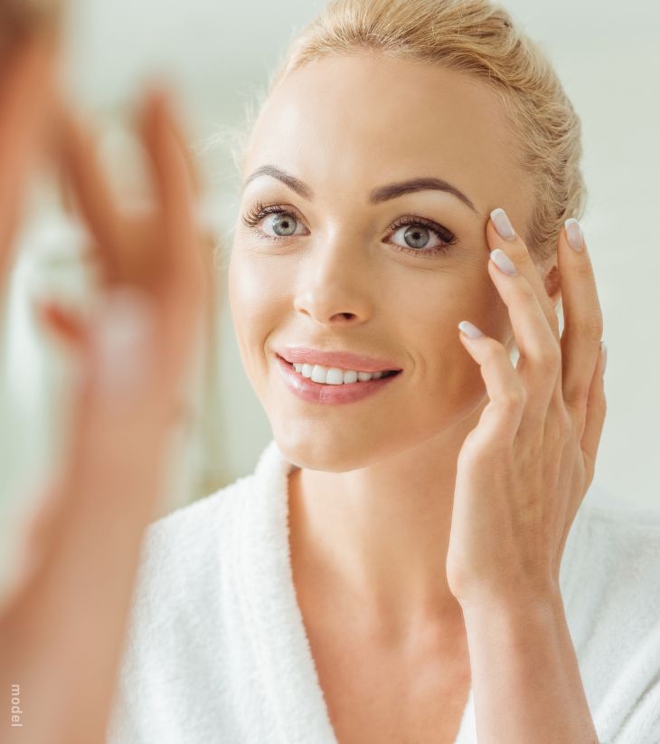 Woman looking at her skin in the mirror