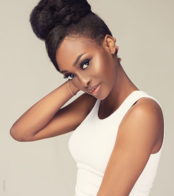Lovely black woman touching the back of her neck