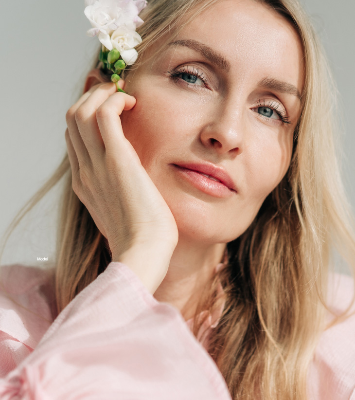 Mature woman in pink with a flower in her hair