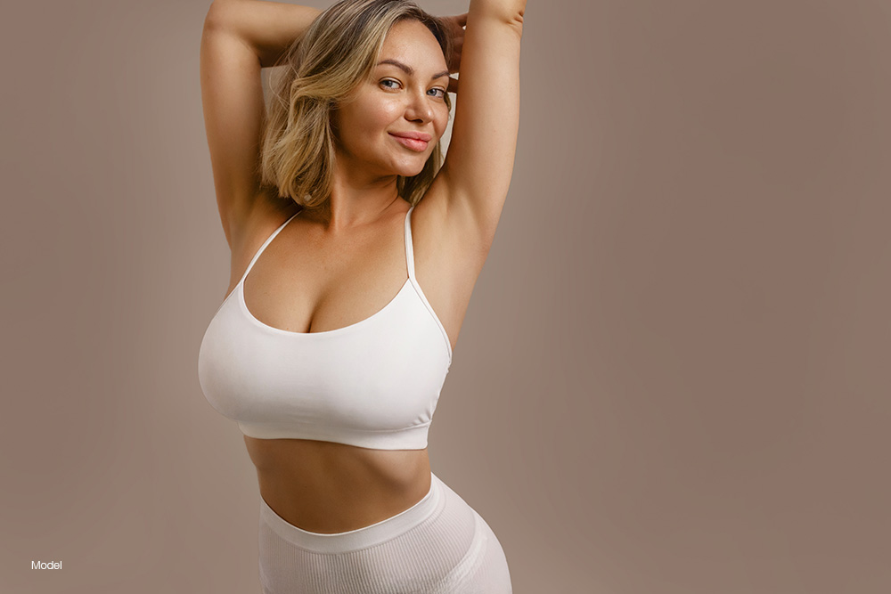 Curvy woman in white sports bra and white yoga pants